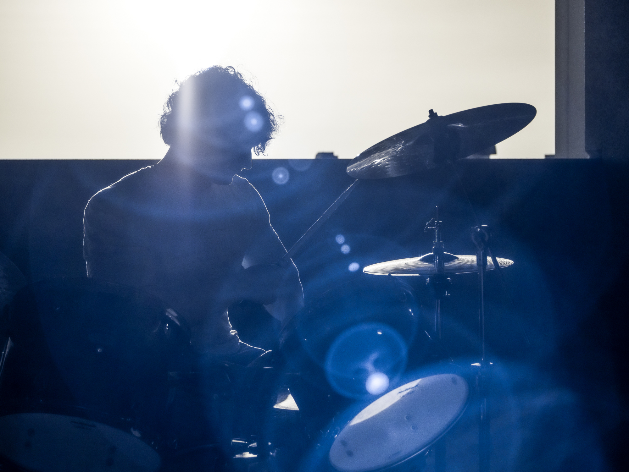 Silhouetted drummer performing